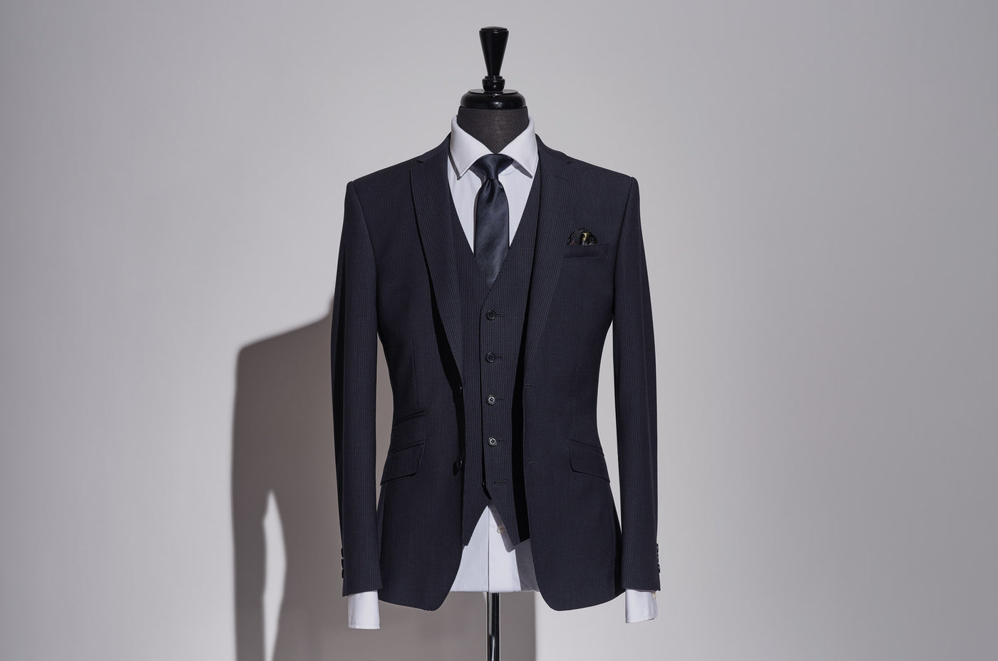 Introducing the second suit collection from Tom Percy. Featuring four British tailored men's three-piece suits.Each suit has a beautifully discreet crimson detail which can be seen on the underside of the collar hinting at the suit’s exquisite exclusivity