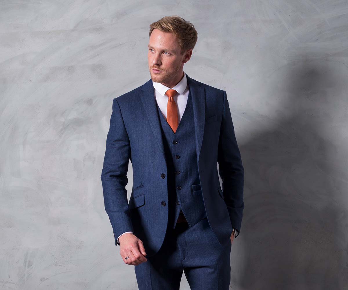 This striking versatile 3-piece suit on the homepage of Tom Percy's website features a timeless yet satisfying blue herringbone tweed pattern. The suit's lining and waistcoat back feature a stunning Escheresque geometric pattern. 